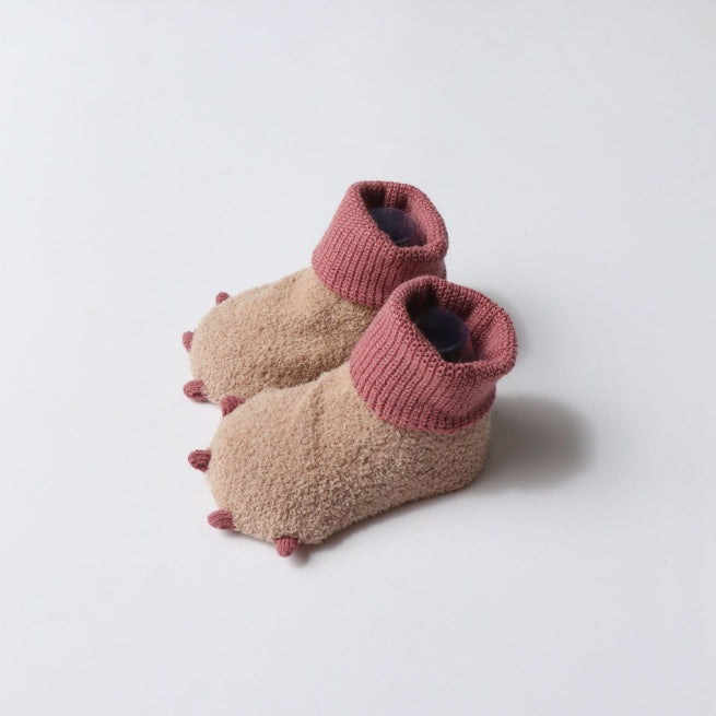 Pair of pink and beige slippers on a white background