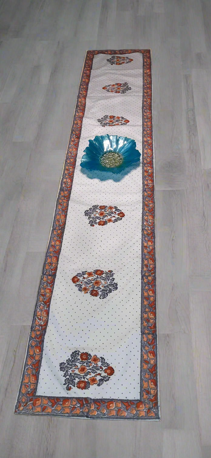 Decorative table runner with floral and leaf patterns on a dark surface