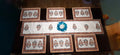 Set of decorative placemats with a central blue emblem on a dark surface