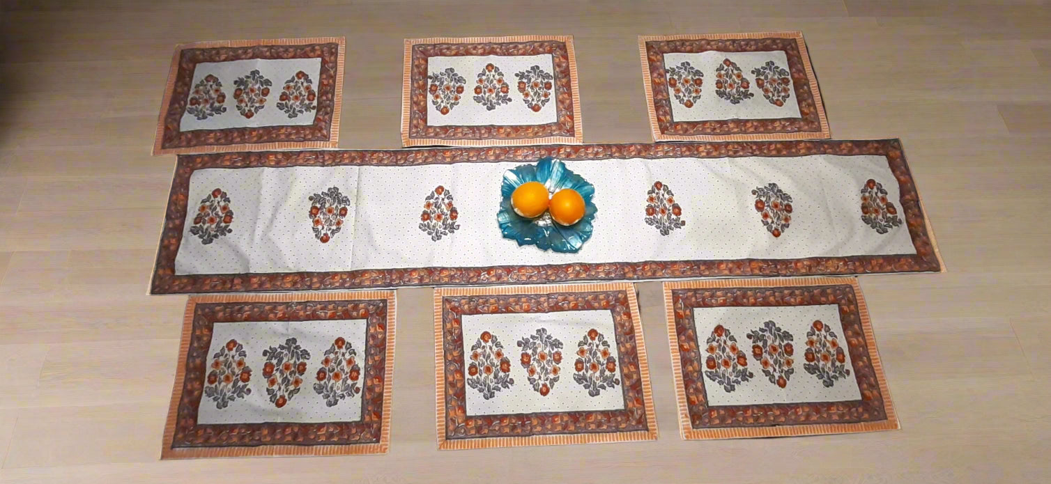 Set of block print decorative placemats on a table with a bowl of fruit.