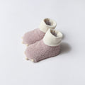 Pair of pink and white baby booties on a light gray background