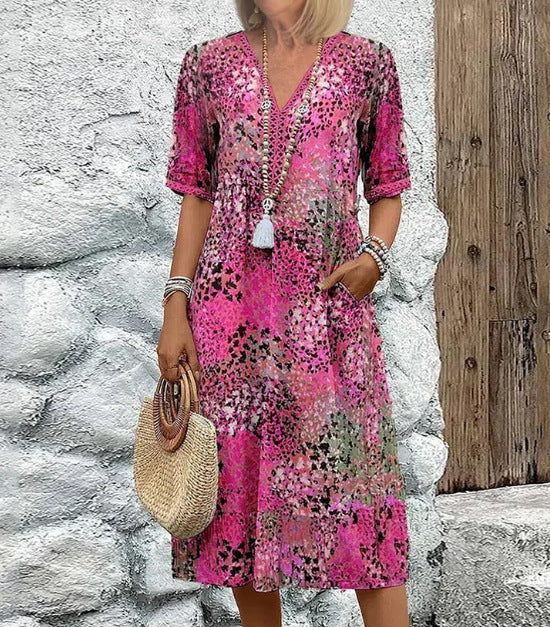 Woman wearing a summer V-neck half-sleeve ethnic print dress with pockets on a sunny beach day