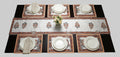 Set of decorative placemats on a table with a bowl of fruit.