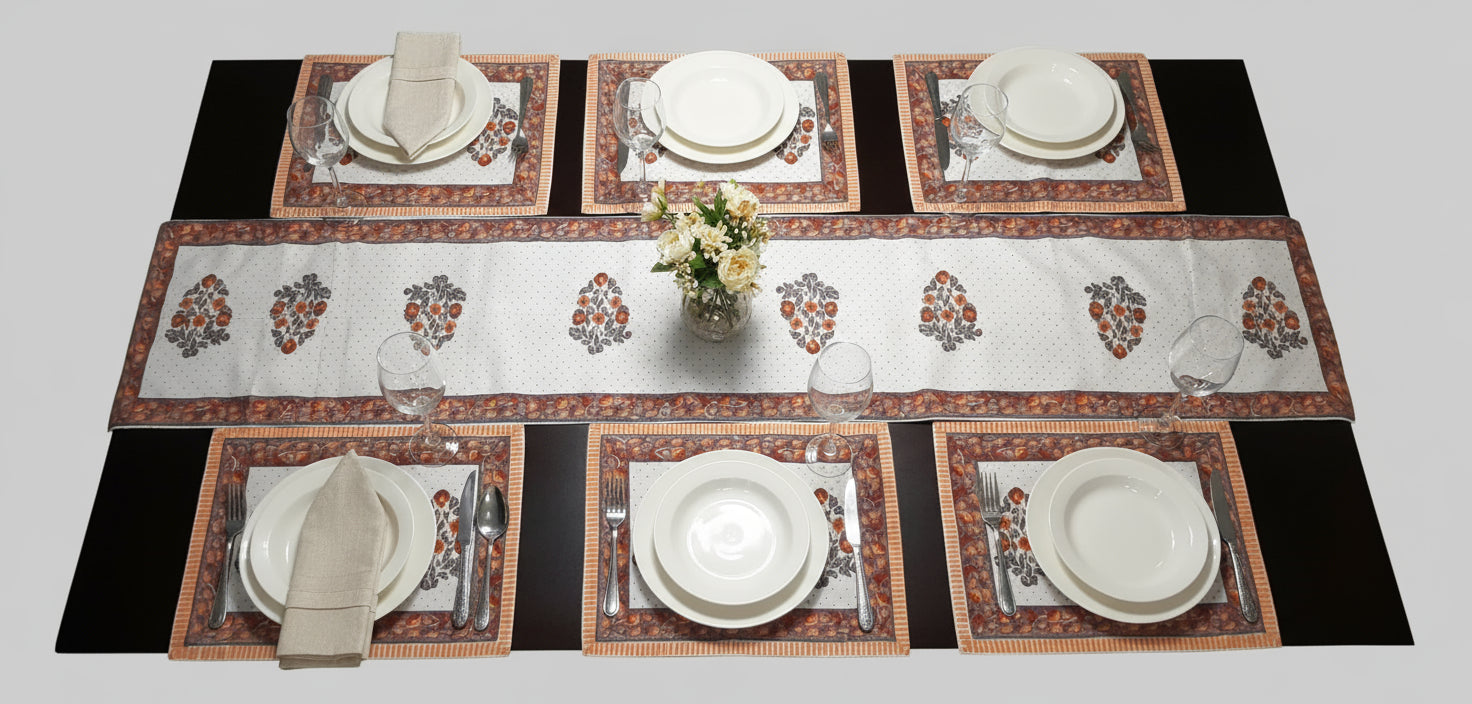 Set of decorative placemats on a table with a bowl of fruit.
